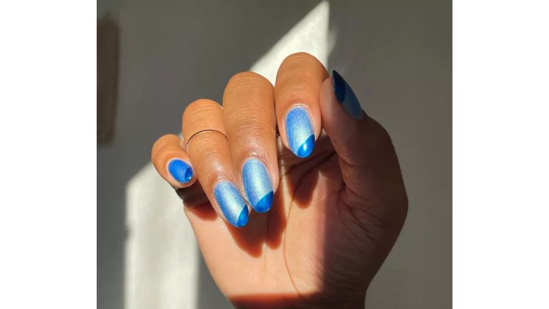 O azul é uma das principais cores paras as unhas em 2023, em decoração metalizada, essa nail art transmite elegância e modernidade.